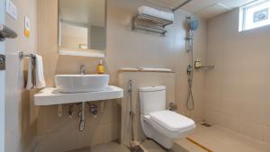 a bathroom with a toilet and a sink and a shower at Bloom Hotel - M Block GK2 in New Delhi +13 photos