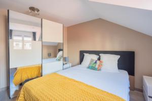 a bedroom with a large bed with a yellow blanket at Le 3 de Coeur Annecy in Annecy