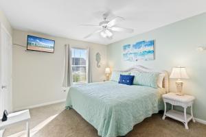 une chambre avec un lit et un ventilateur de plafond dans l'établissement Colony Club Condos, à Gulf Shores