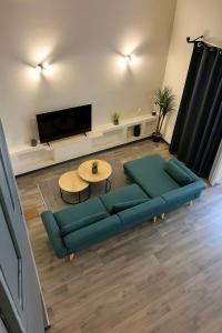 een woonkamer met een blauwe bank en een tv bij Le Loft 15 - Château Fort in Mercury