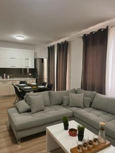 a living room with a couch and a kitchen at Up in Tirana Apartment in Tirana