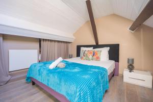 a bedroom with a large bed with a blue blanket at Le 3 de Coeur Annecy in Annecy