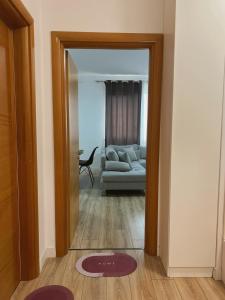 a view of a living room with a couch through a door at Up in Tirana Apartment in Tirana +1 photo