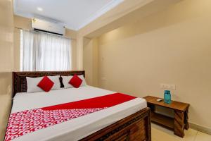a bedroom with a large bed with red pillows at Hotel O RD CONVENTIONS in Visakhapatnam
