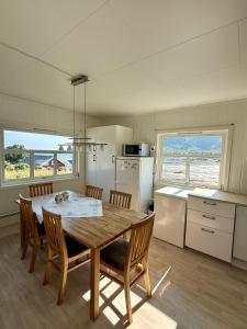 a kitchen with a wooden table and chairs and a kitchen with a table at Peaceful retreat in Lofoten in Sennesvik