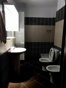 a bathroom with a sink and a toilet and a mirror at Up in Tirana Apartment in Tirana