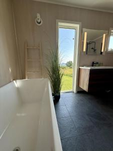 a white bath tub in a bathroom with a window at Peaceful retreat in Lofoten in Sennesvik +5 photos