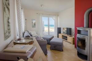 a living room with a couch and a tv and the beach at Ferienhaus Auf der Ostsee in Kappeln