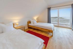 a bedroom with two beds and a large window at Ferienhaus Auf der Ostsee in Kappeln
