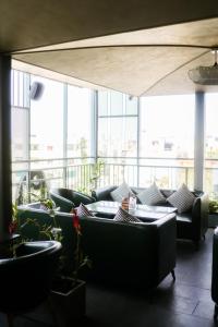 a living room with couches and tables and windows at Hotel Amigos in Bangalore