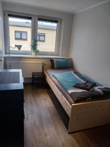 une chambre avec un lit dans une pièce avec une fenêtre dans l'établissement Einzelzimmer mit Bad HG 3, à Zwickau