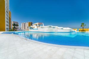 ein großer Pool mit blauem Wasser in einer Stadt in der Unterkunft Luxurious Apartment with Pool View at Caesar Resort Am32 in Perivolia tou Trikomou