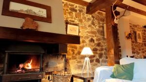 a fireplace in a living room with a stone wall at El Rincón del Besaya in Villasuso de Cieza