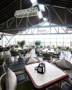 a restaurant with tables and chairs and a large window at Hotel Amigos in Bangalore +122 photos