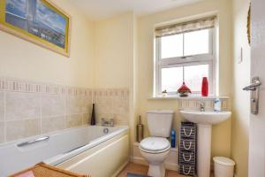 a bathroom with a tub and a toilet and a sink at Your 4 Bedroom Townhouse - Superking Bed in Stamford +48 photos