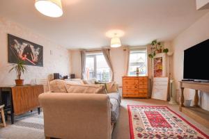 a living room with a couch and a flat screen tv at Your 4 Bedroom Townhouse - Superking Bed in Stamford