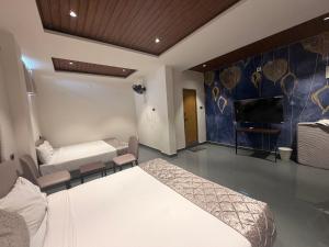 une chambre avec un lit et une télévision à écran plat dans l'établissement Hotel GMR Pearls, à Srikalahasti
