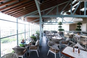 a restaurant with tables and chairs and windows at Hotel Amigos in Bangalore