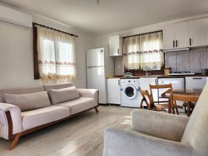 ein Wohnzimmer mit Couch und Tisch und eine Küche in der Unterkunft Olympos NaR Village Nature,Sea and You in Kumluca + 7 Fotos