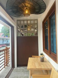 a porch with a wooden table and a ceiling at Inngo Tourist Inn in El Nido
