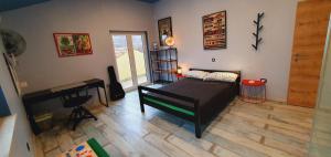 ein Schlafzimmer mit einem Bett, einem Schreibtisch und einem Klavier in der Unterkunft LaRossa House in Dobrinj