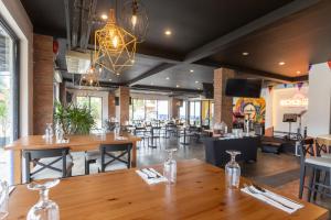 a restaurant with wooden tables and chairs and a chandelier at The Strype Hotel Tagaytay in Tagaytay +43 photos