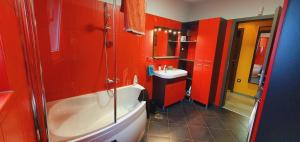ein Badezimmer mit roten Wänden, Badewanne und Waschbecken in der Unterkunft LaRossa House in Dobrinj + 26 Fotos