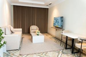 a living room with a couch and a tv at Sara Palace Apartments- family only in Kuwait