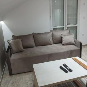 a brown couch in a living room with a coffee table at Stan Na Dan in Velika Plana
