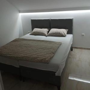 a bed with two pillows on it in a room at Stan Na Dan in Velika Plana