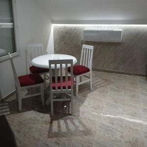 a kitchen with a table and two chairs and a stove at Stan Na Dan in Velika Plana