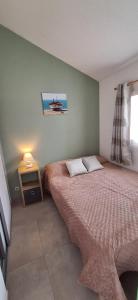 a bedroom with a bed and a table with a lamp at Domaine in Saint-Hilaire-de-Riez