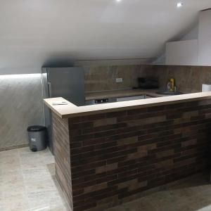a kitchen with a brick counter and a refrigerator at Stan Na Dan in Velika Plana