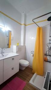 a bathroom with a toilet and a yellow shower curtain at Chambre Luxurieux Gris in Perpignan