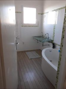 a bathroom with a bath tub and a sink at Chambre Luxurieux Gris in Perpignan