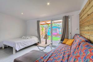 a bedroom with a bed and a window at Ti Kaz Maloya - Saint Paul in Saint-Paul