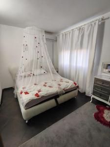 a bedroom with a bed with a mosquito net at Katata Apartment Spacious House Floor with Terraces, 3 Bedrooms, Parking,Wi-Fi in Podgorica