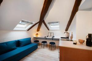 Una sala de estar con un sofá y una cocina con tragaluces. en La Scaletta, en Biella