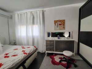 a bedroom with a bed and a dresser and a mirror at Katata Apartment Spacious House Floor with Terraces, 3 Bedrooms, Parking,Wi-Fi in Podgorica