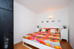 a bedroom with a bed with a colorful comforter at Apartments Nina in Stinica