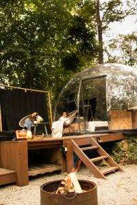 a yurt with two people sitting at a table in front at Dôme design by Out & Lodge in Couvin +15 photos