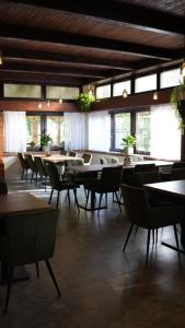 Un comedor con mesas y sillas y ventanas. en Raduňka - Restaurace, Penzion a Wellness, en Opava