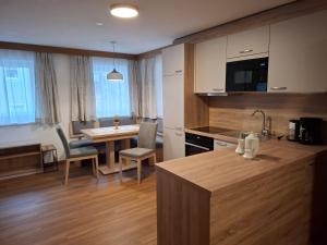 a kitchen and dining room with a table and chairs at WG Appartment in Kleinarl
