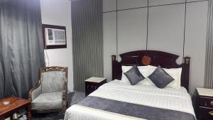 a hotel room with a bed and a chair at فندق كراون نجران الفندقيه in Najran