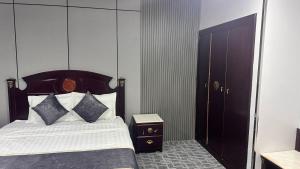 a bedroom with a bed with a wooden headboard at فندق كراون نجران الفندقيه in Najran