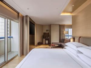a bedroom with a large white bed in a room at Swissotel The Stamford Singapore in Singapore