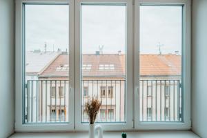 a window with three views of a building at CityBeat Apartments, 400m from the square in Plzeň