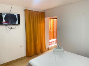 a bedroom with a bed and a television and a window at BOCARENA in Bocapán