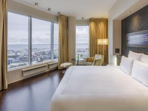 a hotel room with a large bed and large windows at Swissotel Tallinn in Tallinn