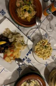 a table with plates of food and bowls of rice at Sunset Dunes Luxury Camp in Merzouga